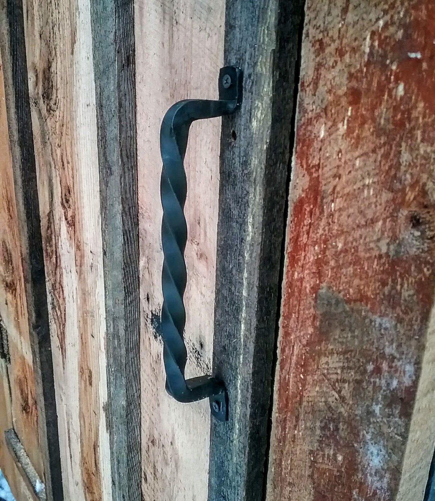 Hand Forged handle made of a single piece of twisted 1/2" steel mounted on a barn door