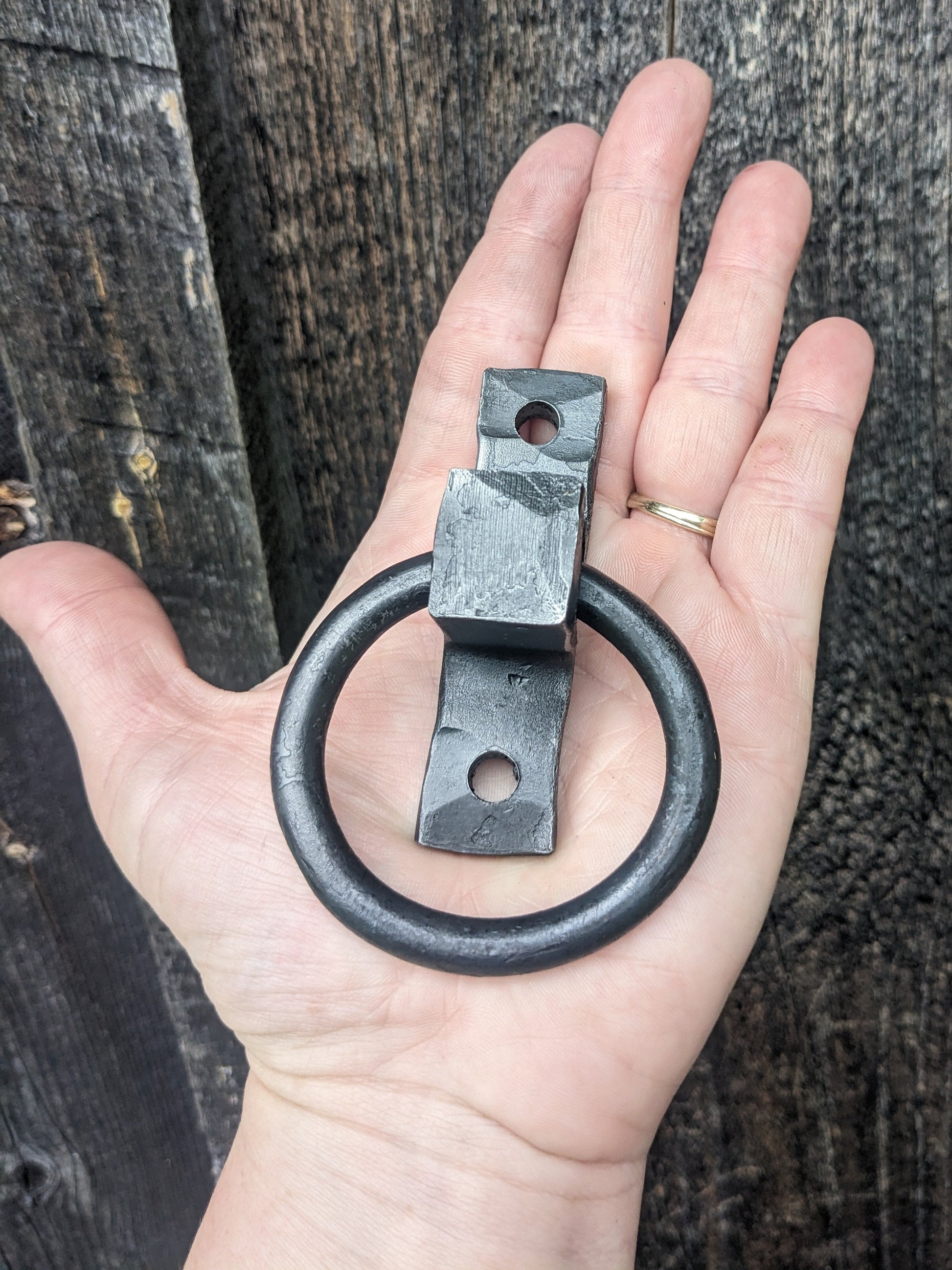 2.25" hand forged blacksmith made ring handle sitting on a woman's hand for size reference.