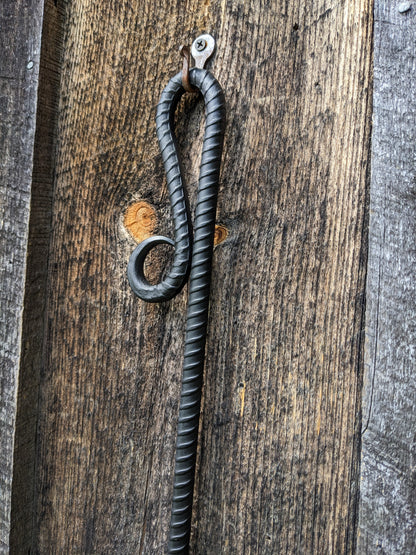 Close up of a handle of a fire poker made of a single piece of round rebar.