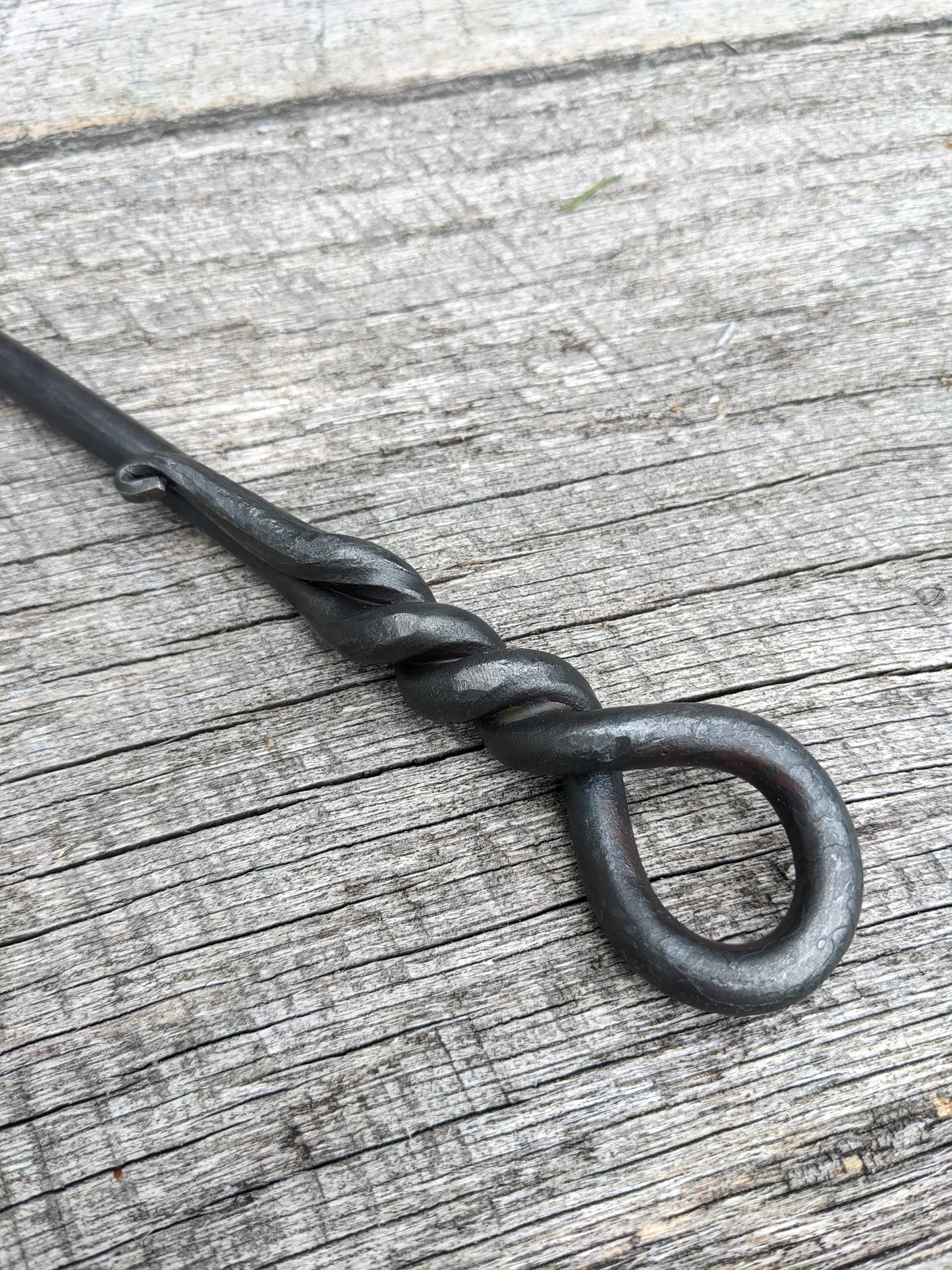 Handle end of the hand forged steak turner.  The metal is wrapped back up upon itself, making a loop that can be used to hang when not in use. 