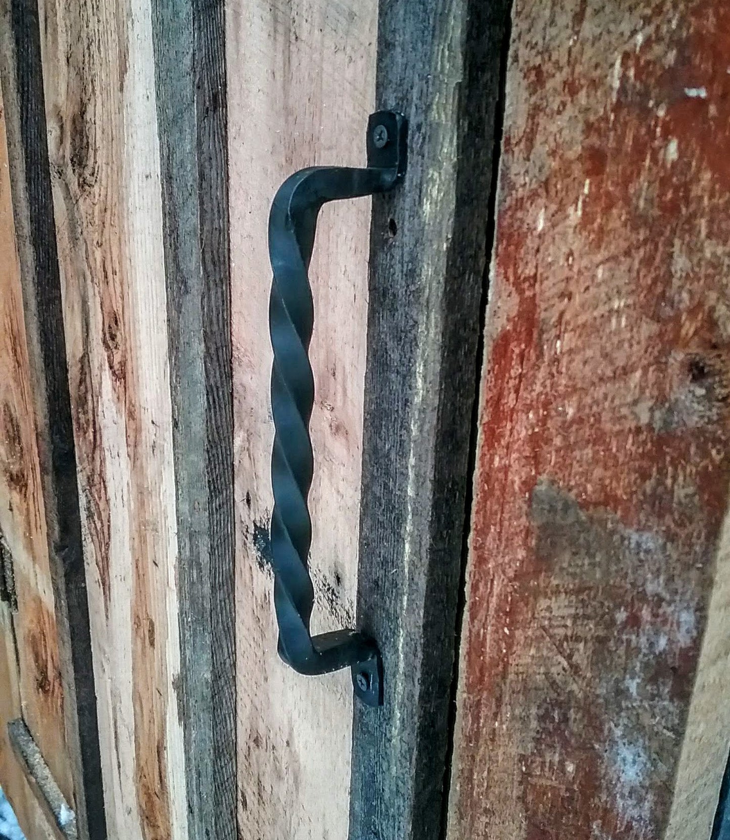 Hand Forged handle made of a single piece of twisted 1/2" steel mounted on a barn door 
